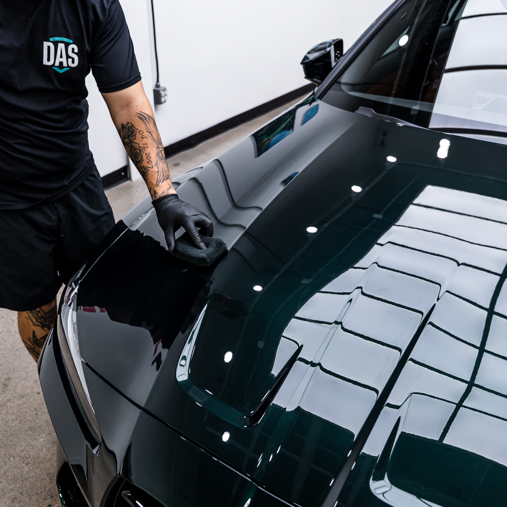 Denver Auto Shield technician wiping down a deep-gloss black hood after ceramic coating application